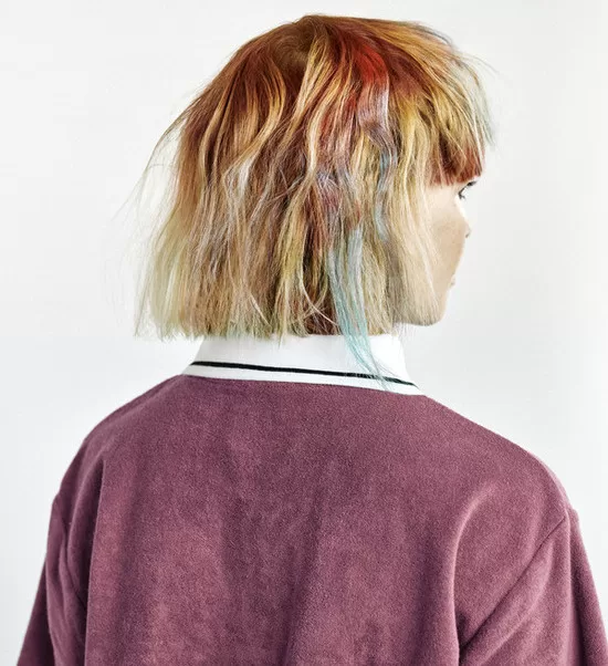 Nikol Hlaváčková je tvůrkyní tohoto účesu. Žena má délku vlasů po ramena a má je červené v pramenech jako by od krve.